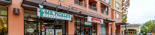 A sign for Mr. Pickle's Sandwiches is on a stand in front of a restaurant.