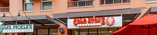 A Hard Stone Creamery storefront with a red umbrella in front.