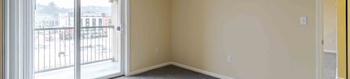 A room with a grey carpet and a yellow door.