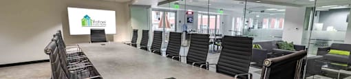A conference room with a long table and chairs, and a sign that reads "Rafael".