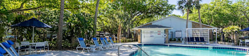 a pool with lounge chairs and a building in the background
