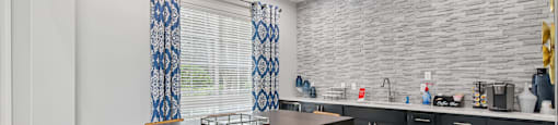A kitchen with a table and chairs.