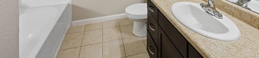 A bathroom with a sink, toilet, and bathtub.