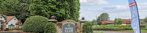 The Grande Club sign is surrounded by a beautiful flower bed.