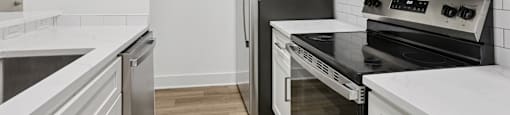 A kitchen with white cabinets and black appliances.