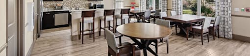 A kitchen with a dining table and chairs.