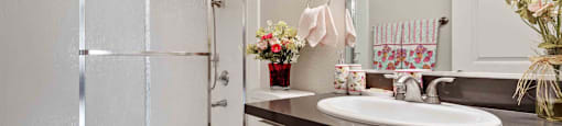 Pet-Friendly Apartments in Daly City, CA - Serra Commons - Bathroom with Large Mirror and Shower Stall with Sliding Frosted Glass Door.