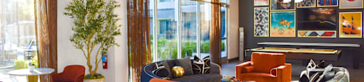 A modern living room with a variety of seating options and a large window.