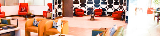 A modern living room with a circular wall design and colorful furniture.