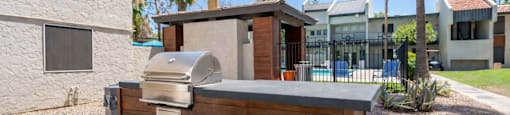 Community outdoor kitchen at Sono Tempe Apartments featuring built-in grills and seating in Tempe, AZ.