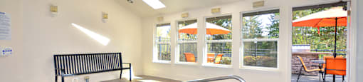 A small indoor pool with a bench and a window.