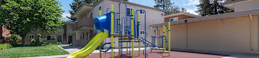 Milpitas Apartments - Spring Valley - Outdoor Community Playground With A Jungle Gym, Soft Cushion Flooring, And Maintained Landscape With Trees
