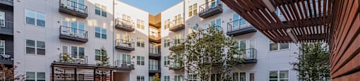 Apartments for Rent in Downtown Dallas, TX - 4600 Ross - Modern Courtyard with Comfortable Seating Options, a Grilling Station, and Beautiful Landscaping