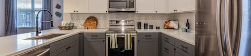 Apartments in Downtown Dallas for Rent- 4600 Ross- Kitchen with Stainless-Steel Appliances and Modern White & Grey Cabinets