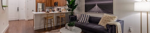 Dog-Friendly Apartments in Old East Dallas, TX - 4600 Ross - Living Room with Hardwood-Style Flooring, Modern Light Fixtures, and Open-Concept Layout with Kitchen