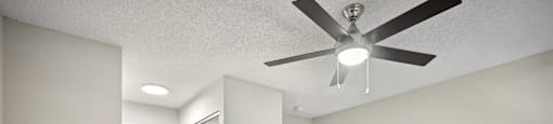 an empty living room with a ceiling fan