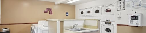 a kitchen with a sink and washes and dryers in it