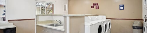 a laundry room with two washing machines and a sink