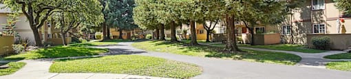 a street with houses and trees and a sidewalk