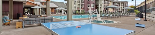Tigard, OR, Apartments with In-Unit Washer and Dryer - Sygnii - A Courtyard with Outdoor Ping Pong Table, Large Swimming Pool, and Lounge Chairs.
