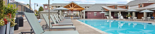 A poolside area with lounge chairs and an umbrella.