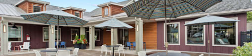 A patio with a table and chairs under an umbrella.