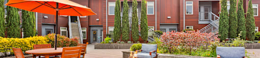 A patio with a fire pit and chairs.