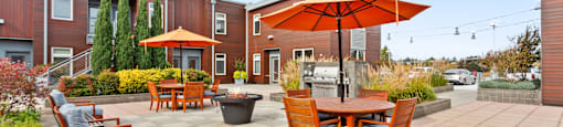 A patio with a table and chairs and an umbrella.