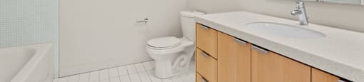 A white bathroom with a toilet, sink, and bathtub.