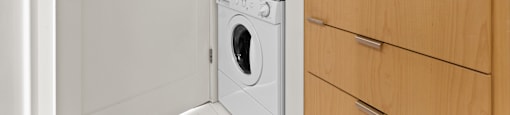 A white dishwasher and washing machine in a small room.