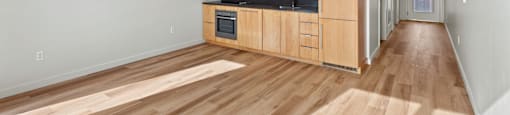 A kitchen with wooden floors and cabinets.