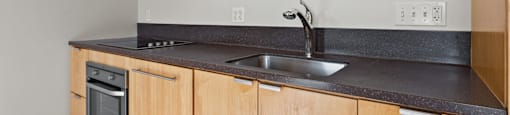 A kitchen with wooden cabinets and a black countertop.