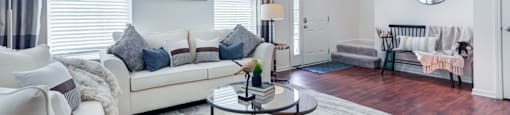 a living room with white furniture and a white rug