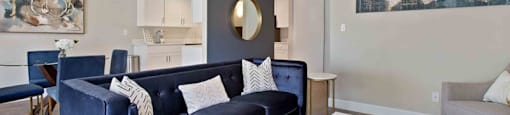 A living room with a blue couch and a white coffee table.