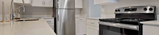 A modern kitchen with stainless steel appliances and white cabinets.