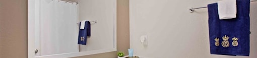 A bathroom with a white sink and a blue towel hanging on the wall.