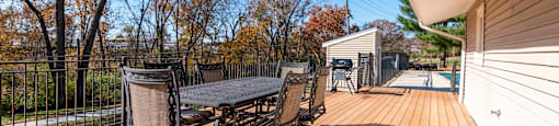 a large deck with a table and chairs and a pool