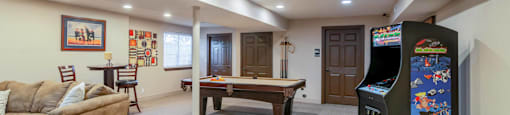 a game room with a pool table and a jukebox
