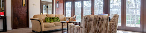 a living room with a couch and chairs and a ceiling fan