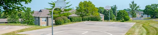 a basketball court in a neighborhood with trees and houses