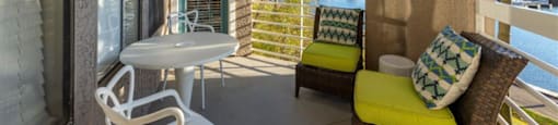 a patio with a table and chairs and a body of water