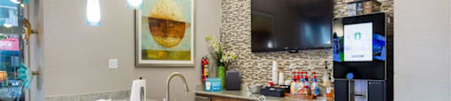 a kitchen with a marble counter top and a tv