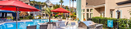 a resort style pool with a bar and tables with umbrellas