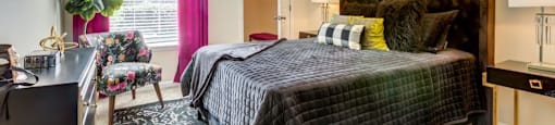 Apartments for Rent in San Antonio, TX - Club at Stone Oak - Bedroom with Plush Carpet Flooring, a Bed, Chair, Dresser, Nightstands, Lamps, Closet, and Window