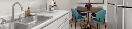 A kitchen with a table and chairs.