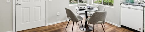 A dining room with a table and chairs.