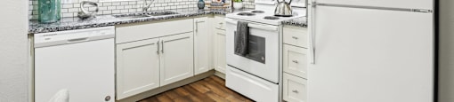 A kitchen with white appliances and cabinets.