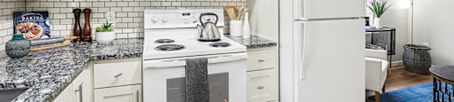 A white kitchen with a refrigerator, stove, and microwave.