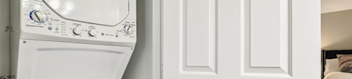 A white washing machine is next to a white door.