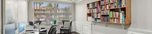 A room with a desk, chairs, and a bookshelf.